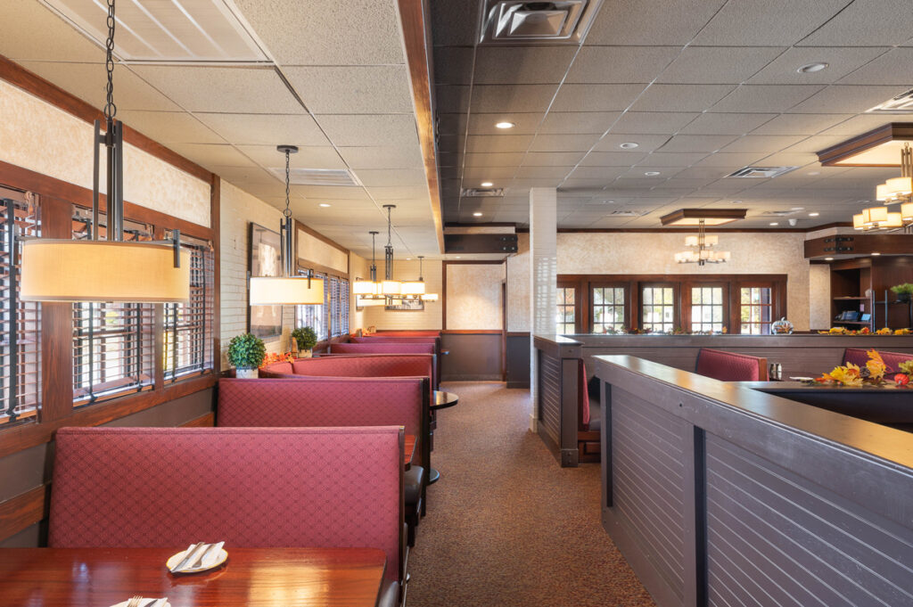 Comfortable booth seating inside The Chateau, featuring warm lighting, wooden accents, and a spacious dining layout.