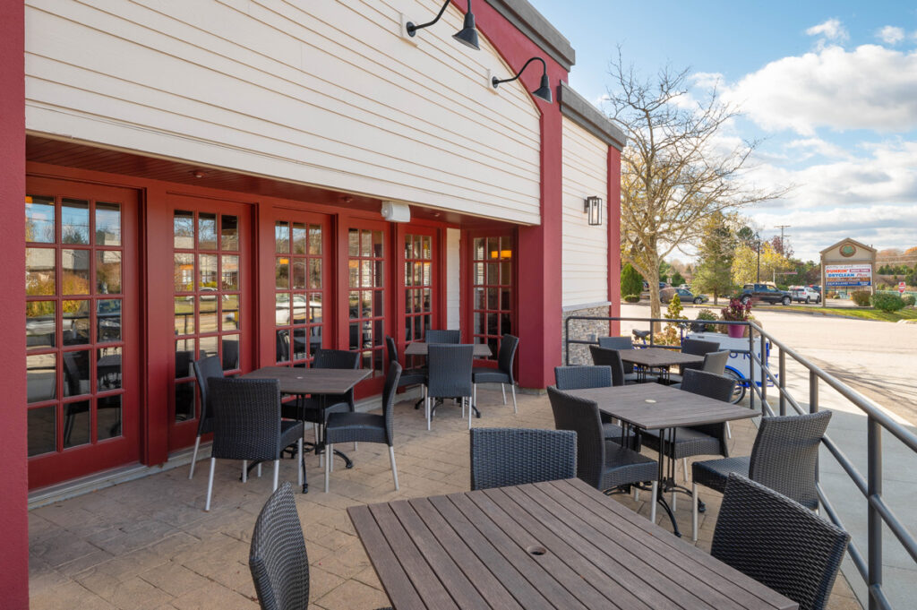 Outdoor patio seating at The Chateau restaurant with tables and chairs along the building exterior.