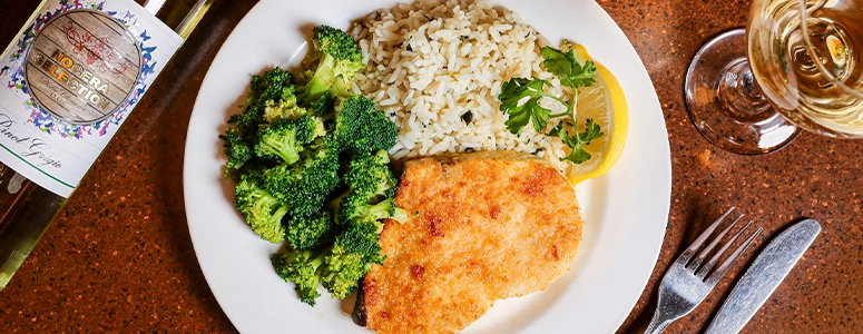 Plate of baked haddock with rice and choice of vegetable